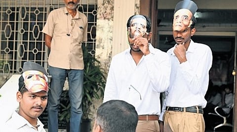 Youth Congress members wear RSS uniform during a protest outside the KPCC office in Bengaluru on Thursday.