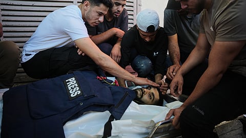 Palestinians mourn over the body of Al Jazeera cameraman Ahmed Wishah, who was killed in an Israeli airstrike, during his funeral at Al-Aqsa Hospital in Deir al-Balah, central Gaza Strip, Sunday, June 21, 2026.