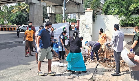 Local residents clean a stretch of Bannerghatta Road on Sunday.
