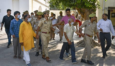 Police personnel escort the accused to a court in connection with the alleged embezzlement of Ram Temple donation funds, in Ayodhya.