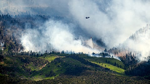 A helicopter drops water on the Cottonwood Fire burning near Beaver, Utah, on Saturday, June 27, 2026.