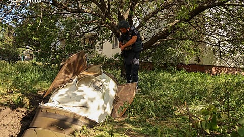 In this photo provided by the Ukrainian Emergency Service, a sapper examines a fragment of the Russian missile in a residential neighbourhood following an air attack in Kyiv, Ukraine, Sunday, June 28, 2026.