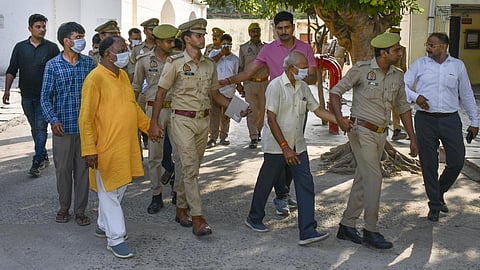 Police personnel escort the accused to a court in connection with the alleged embezzlement of Ram Temple donation funds in Ayodhya on Friday (June 26, 2026).