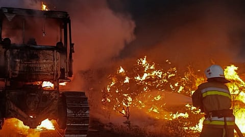A rescue worker puts out a fire of a tractor destroyed by a Russian strike on Mykolaiv region, Ukraine.