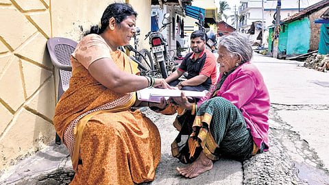 A Booth Level Officer verifies voter details of an elderly woman during the SIR exercise, in Chikkamagaluru on Tuesday.