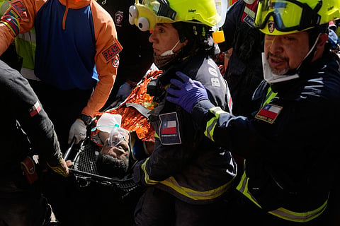 Chilean rescue workers carry Hernán Alberto Gil Flores after he was pulled from the rubble eight days after he was trapped by twin earthquakes that struck Catia La Mar, Venezuela, Thursday, July 2, 2026.