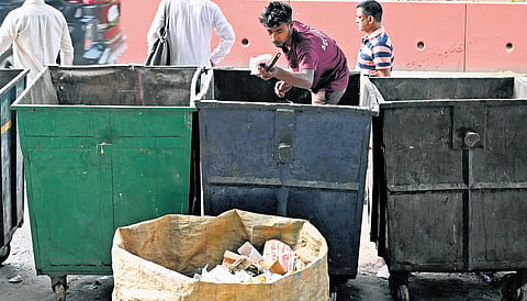 Sanitation workers (above and left) start collecting urban waste even before Delhi wakes up