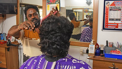 A hairdresser working in a salon in Tiruchy.