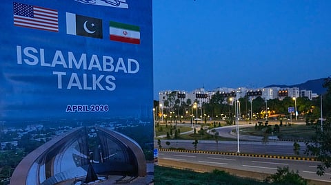 A billboard of the US-Iran talks is seen near the Serena Hotel, the venue for the official meeting between both nations, in Islamabad, Pakistan, Sunday, April 12, 2026.