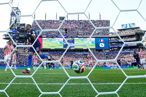 Kylian Mbappe wheels away in celebration after converting a penalty against Paraguay on Saturday