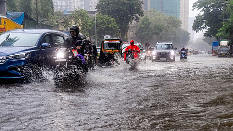 Commuters wade through a waterlogged road at Matunga, in Mumbai, Maharashtra, Saturday, July 4, 2026.