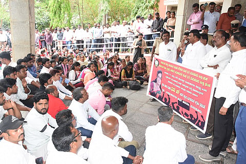 The government employees association members staging dharna at DCs office in Tumakuru in protest of SIR superviser Bhuvanas death in a mishap alleging work pressure as the cause on Saturday. The victim Bhuvana.