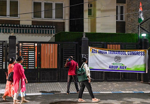 People walk past a banner of the rebel faction of Trinamool Congress (TMC) displayed outside the Trinamool Bhavan, in Kolkata, West Bengal, Friday, July 3, 2026. The battle for control of the TMC escalated dramatically on Friday when the rebel faction led by Leader of the Opposition Ritabrata Banerjee took charge of the party's Metropolitan headquarters in Kolkata, changed the locks, put up fresh posters and declared it would henceforth operate from the premises.