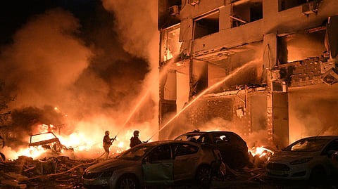 Emergency services personnel work to extinguish a fire following Russian missile attacks in Kyiv, Ukraine, Monday, July 6, 2026.