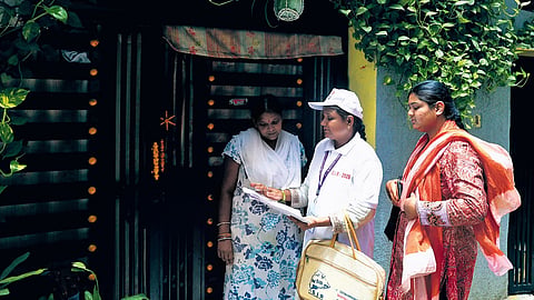 A booth level officer distributes enumeration forms to residents at Banjara Hills in Hyderabad on Thursday.