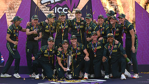 Australia's captain Sophie Molineux holds the trophy as Australia celebrate on the podium after the ICC Women's T20 cricket world cup 2026 final between Australia and England, at Lord's in London on July 5, 2026.