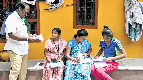 Officials verify documents of residents during the enumeration drive under the SIR process at Gowlipura in Hyderabad on Monday.
