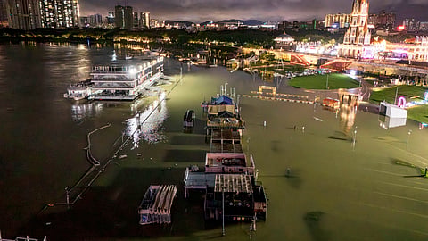 A flooded riverside walkway and shops are seen near a wharf on the Yongjiang river in Nanning, in China’s southern Guangxi region on July 6, 2026.