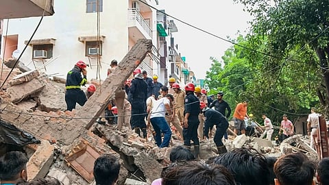 Officials conduct a rescue operation after an under-construction building collapsed at Rohini amid heavy rainfall, in New Delhi, Wednesday, July 8, 2026.