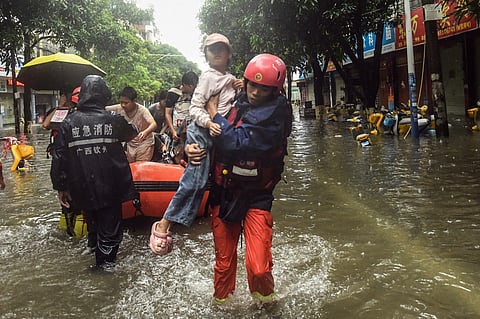 In this photo released by Xinhua News Agency, rescuers evacuate stranded residents in the aftermath of tropical storm Maysak in Qinzhou City, south China's Guangxi Zhuang Autonomous Region Tuesday, July 7, 2026.