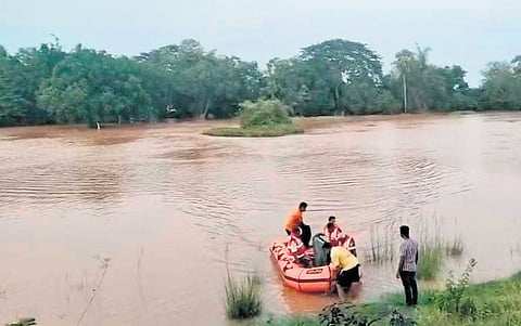 The fire services team crossing the swollen Mahanadi river to reach the island