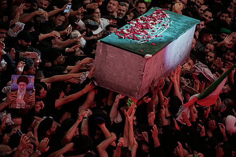 The flower petal-covered coffin of the late Iranian Supreme Leader Ayatollah Ali Khamenei is carried above mourners reaching out to touch it outside the Imam Hussein Shrine in Karbala, Iraq, early Thursday, July 9, 2026.
