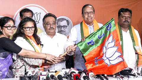 West Bengal BJP President Samik Bhattacharya holds the party's flag as former Trinamool Congress MPs Sushmita Dev, Sukhendu Sekhar Roy, and Prakash Chik Baraik join BJP, in Kolkata on Thursday.