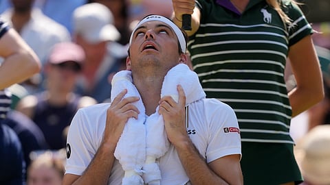 Taylor Fritz of the United State uses ice packs in a towel to cool during the men's singles quarter-final match against Alexander Zverevof Germany at the Wimbledon Tennis Championships in London, Wednesday, July 8, 2026.