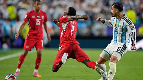 Switzerland's Breel Embolo (7) reacts as he dives in a challenge from Argentina's Leandro Paredes (5) for which he got a second yellow card