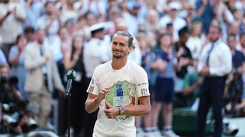 Alexander Zverev of Germany holds his trophy after losing against Jannik Sinner of Italy in the men's singles final at Wimbledon Tennis Championships in London, Sunday, July 12, 2026.