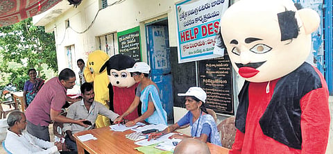 People dressed as popular cartoon characters, like Motu Patlu & Mickey Mouse, help residents during an SIR awareness programme at Medaripet village on Sunday