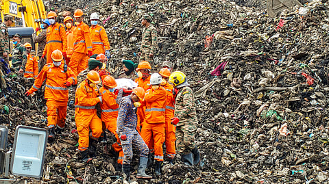 Rescue personnel carry a body during rescue operations at the site where a three-storey administrative building collapsed at the Pimpri Chinchwad Municipal Corporation's waste-to-energy plant in Moshi following heavy rainfall, in Pune, Thursday, July 9, 2026.