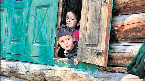 Children peeking out of their wooden houses
