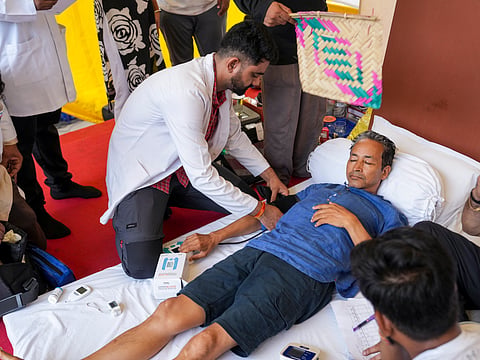Climate activist Sonam Wangchuk being attended by a medical professional as Cockroach Janata Party (CJP) founder Abhijeet Dipke looks on during a protest by CJP demanding Union Education Minister Dharmendra Pradhan's resignation over alleged irregularities in the NEET examination, at Jantar Mantar, in New Delhi.