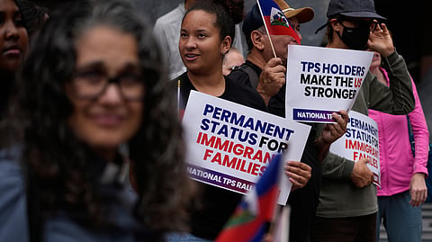 People hold Haitian flags and signs during a rally in support of immigrants living in the United States, Thursday, July 9, 2026, in San Diego.