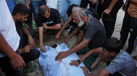 Mourners take the last look at the body of a Palestinian man who was killed following an Israeli airstrike during his funeral in Nuseirat, central Gaza Strip, Friday, July 17, 2026.