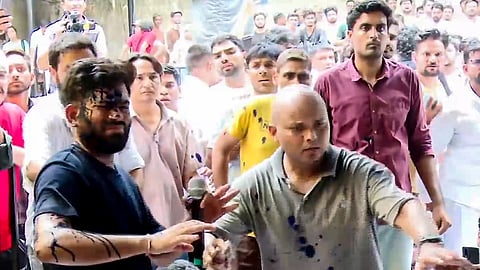 Cockroach Janata Party (CJP) founder Abhijeet Dipke reacts after a woman threw an ink-like liquid on him as he begins an indefinite hunger strike at Jantar Mantar, in New Delhi, Saturday, July 18, 2026.
