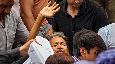 Activist Sonam Wangchuk, who has been on an indefinite hunger strike for 21 days, waves as he is shifted to a hospital from Jantar Mantar, in New Delhi, Saturday, July 18, 2026.