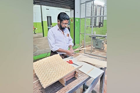 An artisan from Urali tribe making mirror mat
