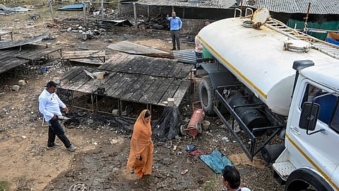 People inspect the site of a blast and fire at an illegal firecracker factory in the Ramol area in Ahmedabad, Gujarat, on Saturday, July 18, 2026.