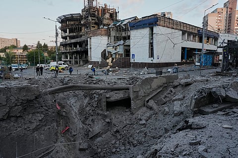 Debris surrounds a missile crater in the foreground of a building following Russia's missile attack in Kyiv, Ukraine, Sunday, July 19, 2026