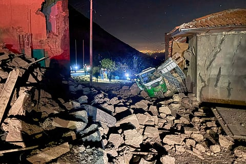 A motor tricycle is stuck amid the debris of homes that collapsed after an earthquake struck Pumpuya, Peru, Sunday, July 19, 2026.