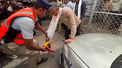 Minister Krishna Byre Gowda locks an abandoned vehicle near Varahi Temple in the Gandhinagar Assembly constituency on Saturday.