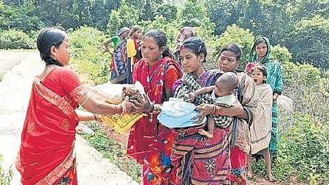 The Anganwadi worker providing supplies to villagers at the roadside.