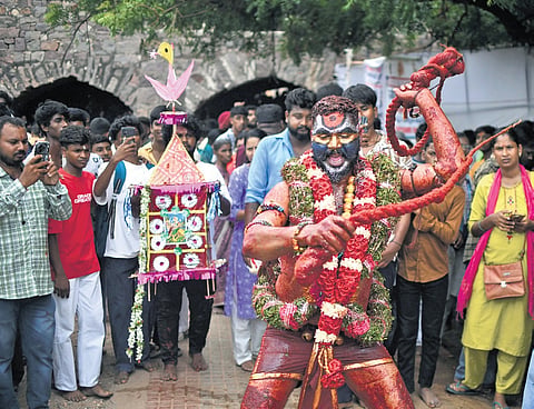 A Pothuraju dances with a whip during the procession to the Sri Jagadambika Mahankali temple, Golconda Fort in Hyderabad