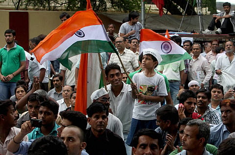 A child waves a Tricolour as he participates in Team Annas agitation against corruption at Jantar Mantar in New Delhi