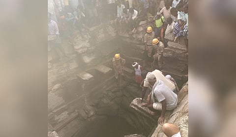 People gather around the open well on the premises of Kalleshwara Temple in Bagali village of Harapanahalli taluk, Vijayanagara district.