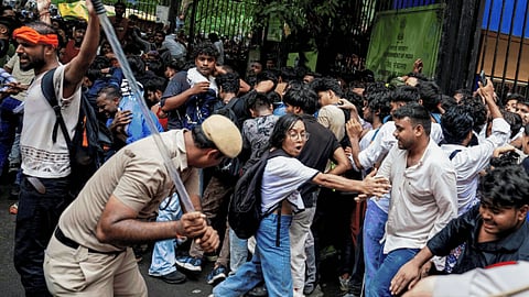 Security personnel stop Cockroach Janata Party (CJP) supporters as they raise slogans at Jantar Mantar protest march, in New Delhi.