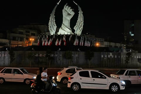 Vehicles drive past a monument depicting the clenched fist of the late Iranian Supreme Leader Ayatollah Ali Khamenei, who was killed in the U.S. and Israel strike on Feb. 28, in Islamic Revolution Square in Tehran, Sunday, July 19, 2026.