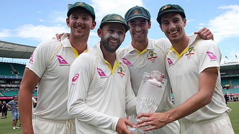 Australian bowlers Josh Hazlewood, left, Nathan Lyon, Mitchell Starc, second right, and Pat Cummins, right, hold the Ashes trophy as they celebrate at the end the last day of their Ashes cricket test match against England in Sydney, Jan. 8, 2018.